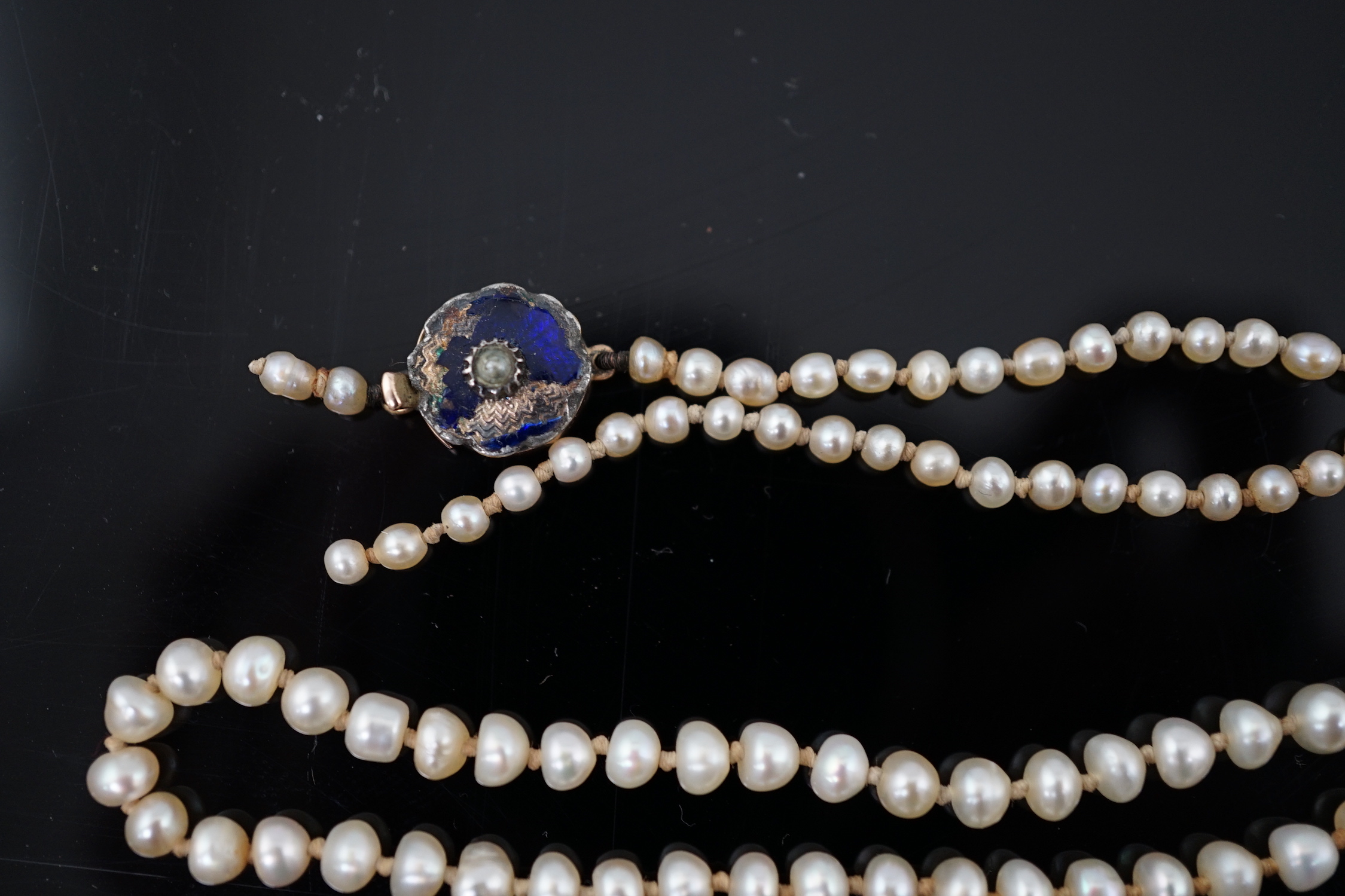 A Victorian single strand graduated natural saltwater pearl necklace, with seed pearl and enamel set gold clasp